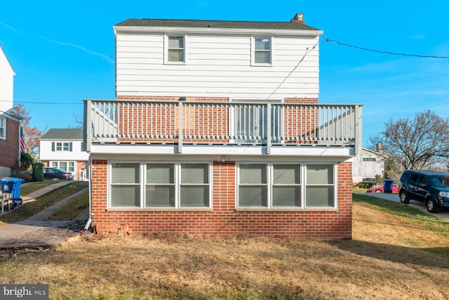 back of property with a lawn and a balcony