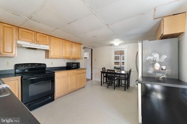 kitchen featuring light floors, dark countertops, light brown cabinets, under cabinet range hood, and black appliances