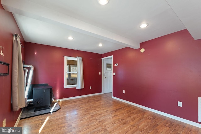 interior space with recessed lighting, visible vents, a wood stove, wood finished floors, and baseboards