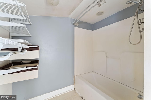 bathroom featuring bathtub / shower combination and baseboards