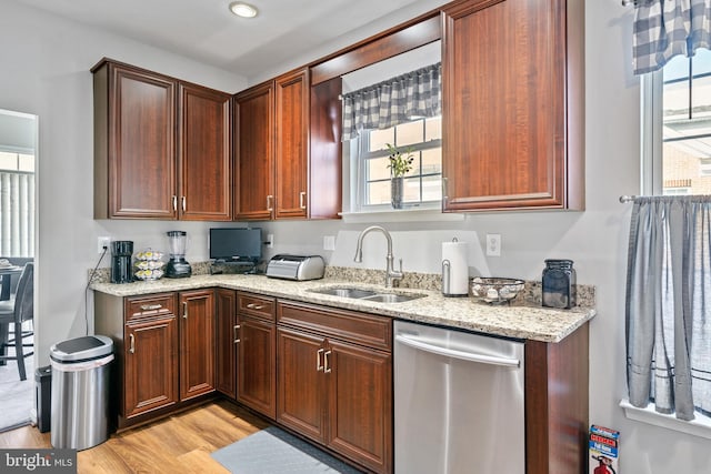 kitchen with sink, light hardwood / wood-style flooring, stainless steel dishwasher, and light stone counters