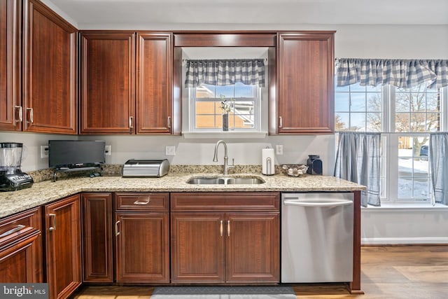 kitchen with sink, a wealth of natural light, dishwasher, and light stone counters