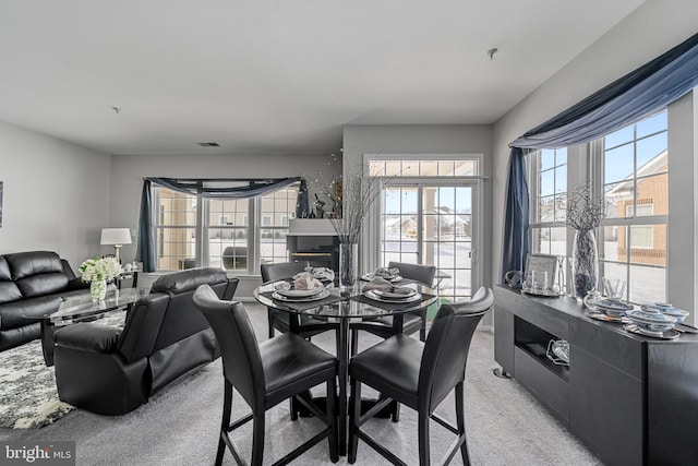 carpeted dining area featuring plenty of natural light