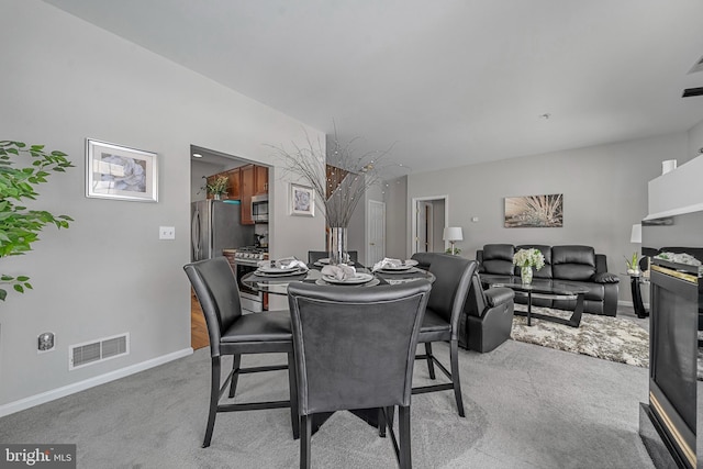 dining space featuring light carpet