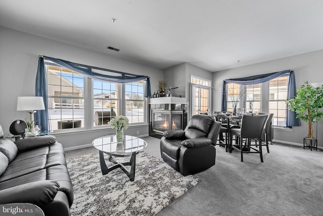 carpeted living room with a fireplace and a healthy amount of sunlight