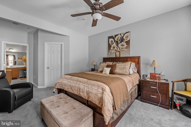 carpeted bedroom with ensuite bath and ceiling fan