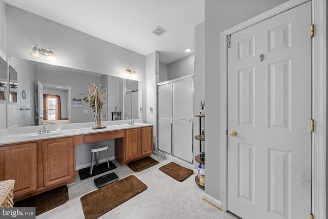 bathroom featuring a shower with shower door and vanity