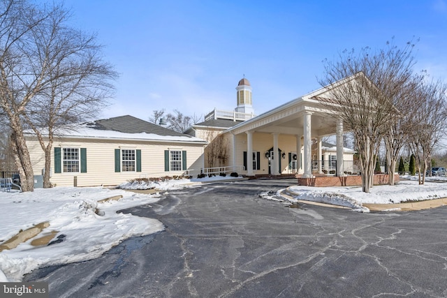 snow covered rear of property with a porch