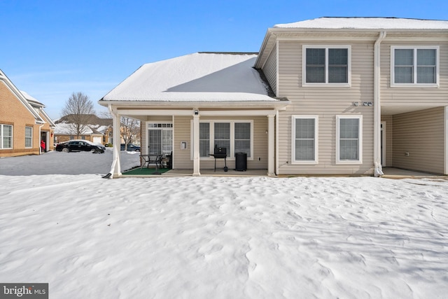 view of snow covered rear of property