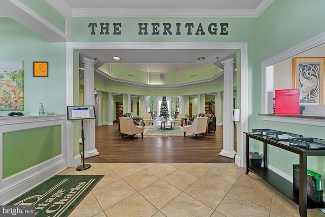 foyer with decorative columns, crown molding, and light tile patterned floors