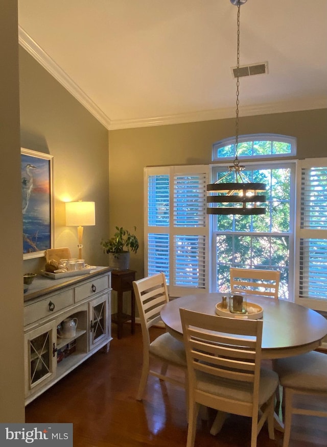 dining room with ornamental molding, lofted ceiling, a chandelier, and dark hardwood / wood-style floors