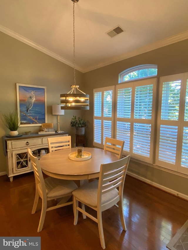 dining area featuring dark hardwood / wood-style flooring, crown molding, and a healthy amount of sunlight