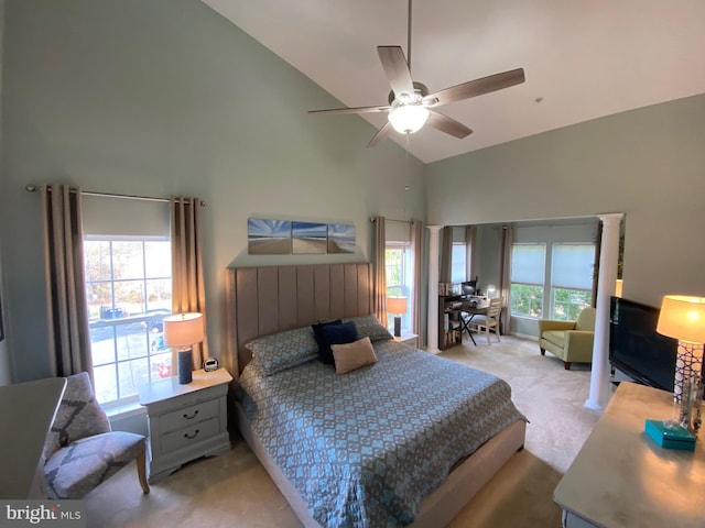 bedroom featuring ceiling fan, decorative columns, high vaulted ceiling, and light carpet