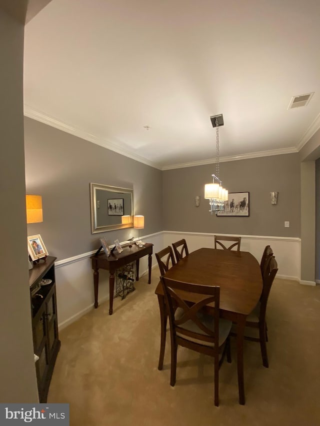 dining space featuring carpet floors and crown molding