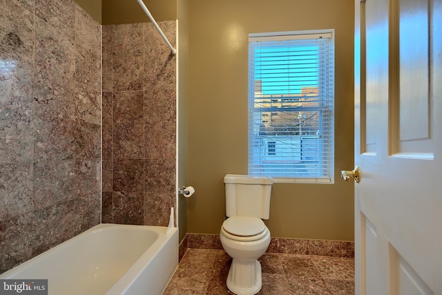 bathroom featuring washtub / shower combination and toilet