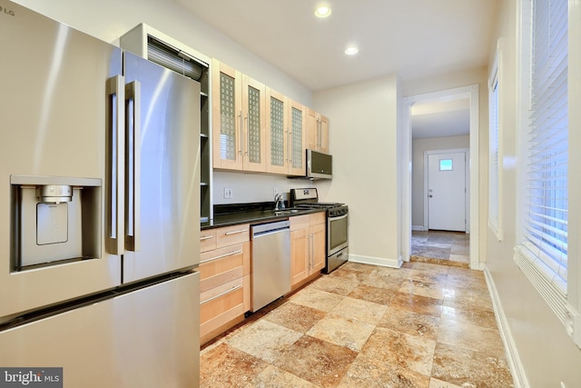 kitchen featuring stainless steel appliances, light brown cabinets, and sink