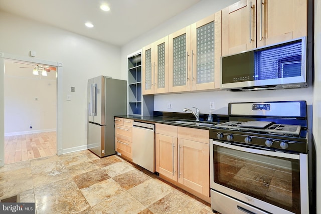 kitchen with appliances with stainless steel finishes, ceiling fan, sink, and light brown cabinets