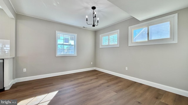 unfurnished dining area with an inviting chandelier and hardwood / wood-style flooring