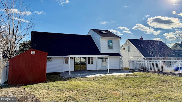 rear view of property with a patio, a storage unit, and a lawn