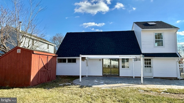 back of house featuring a patio area, a yard, and a storage shed