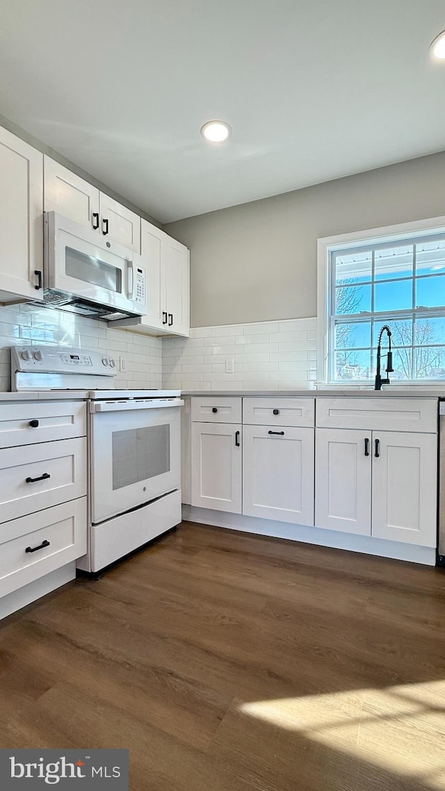 kitchen with white appliances, dark hardwood / wood-style floors, white cabinets, and sink