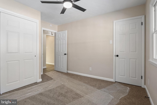 unfurnished bedroom with ceiling fan, light colored carpet, and a closet