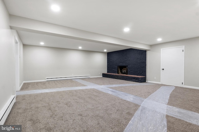 basement with a baseboard radiator, a fireplace, and light carpet