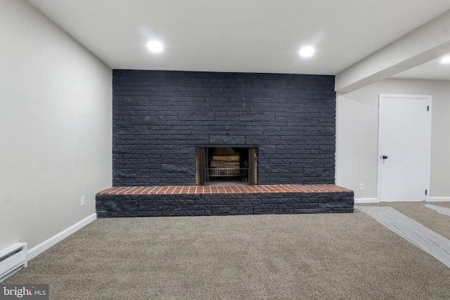 unfurnished living room with a large fireplace, a baseboard heating unit, and carpet flooring