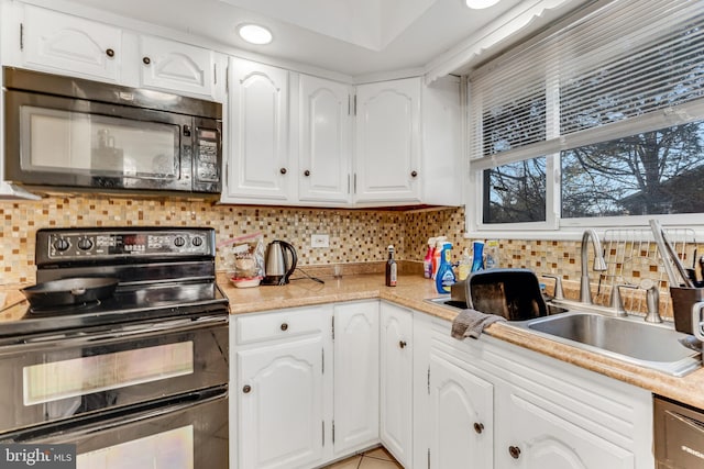 kitchen featuring white cabinetry, sink, decorative backsplash, and black appliances