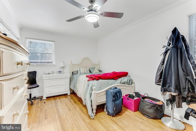 bedroom featuring ceiling fan, crown molding, and light hardwood / wood-style flooring