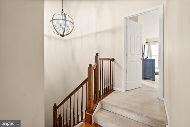 stairs featuring a notable chandelier and carpet flooring