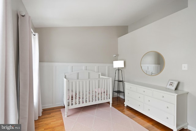 bedroom featuring a nursery area and hardwood / wood-style floors