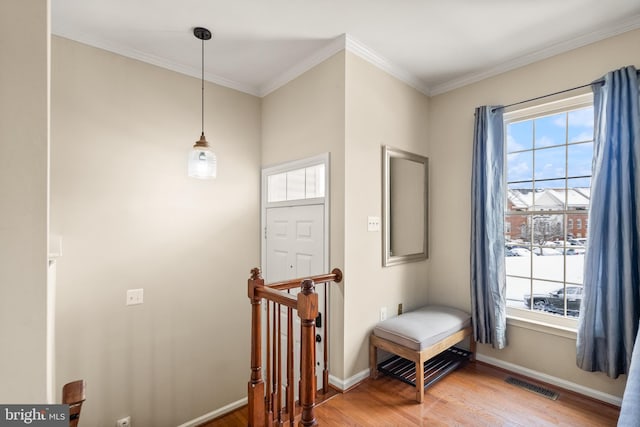 entryway with plenty of natural light, hardwood / wood-style floors, and crown molding