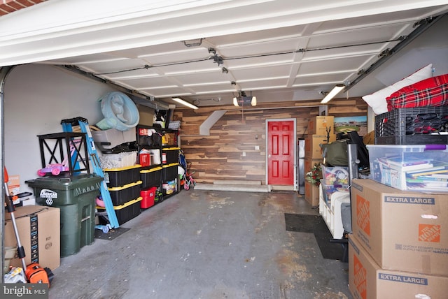 garage featuring a garage door opener and wood walls