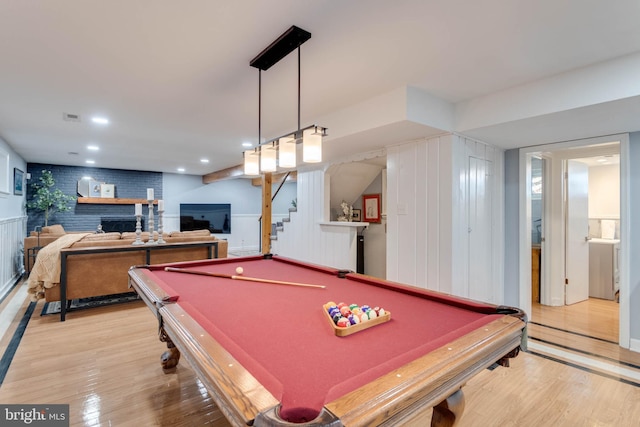 rec room featuring pool table, a fireplace, and light wood-type flooring