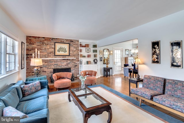 living room with hardwood / wood-style flooring, a fireplace, and built in features