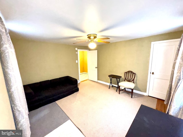 living area with carpet and ceiling fan