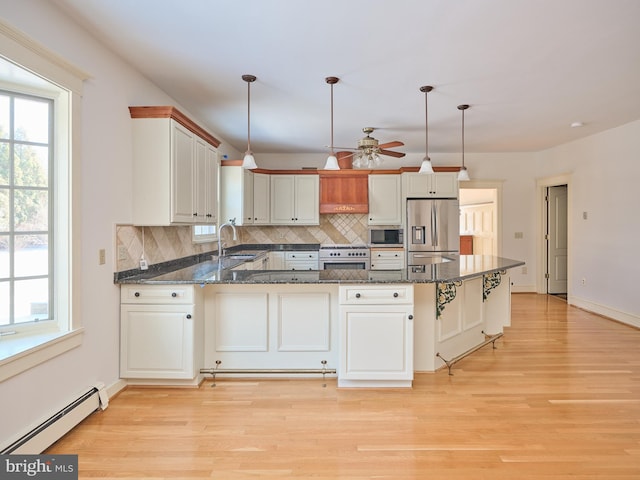 kitchen featuring hanging light fixtures, a baseboard heating unit, appliances with stainless steel finishes, and kitchen peninsula