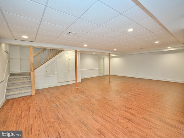 basement featuring light hardwood / wood-style floors and a drop ceiling