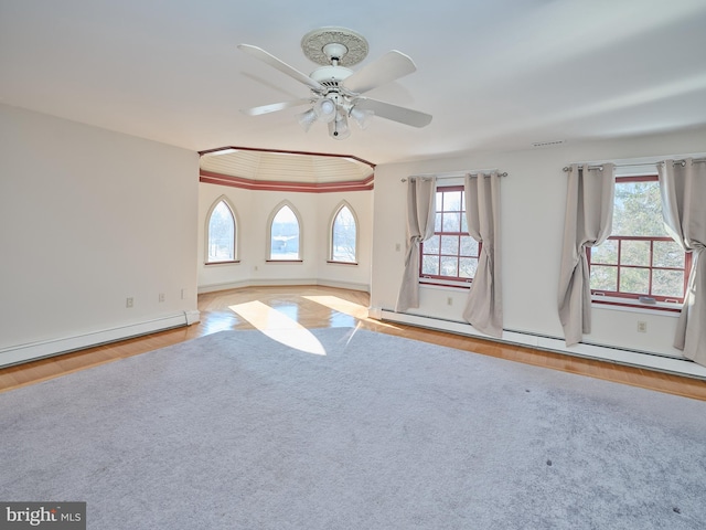 unfurnished room with ceiling fan, a baseboard heating unit, and light wood-type flooring