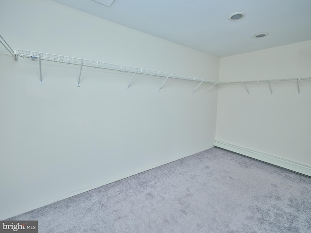 walk in closet with baseboard heating and light carpet