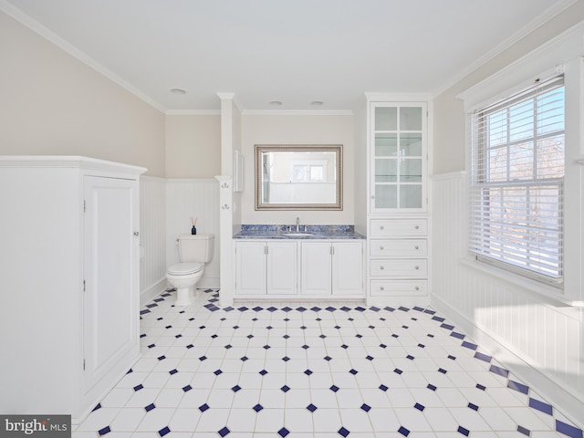 bathroom with toilet, vanity, and crown molding