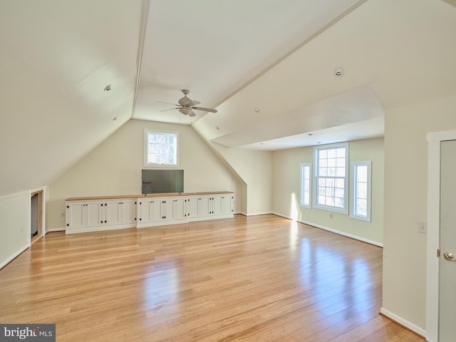 additional living space featuring light hardwood / wood-style floors, plenty of natural light, ceiling fan, and vaulted ceiling