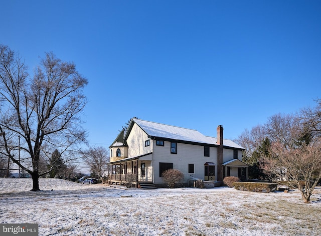 view of snow covered rear of property