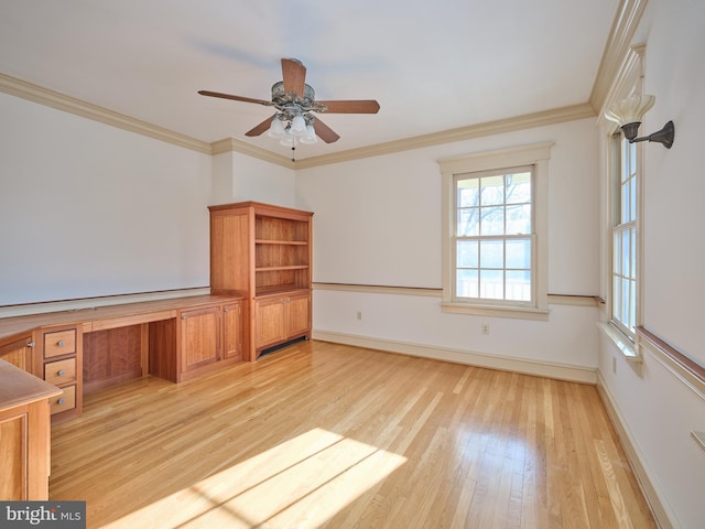 interior space featuring crown molding, built in desk, light hardwood / wood-style floors, and ceiling fan