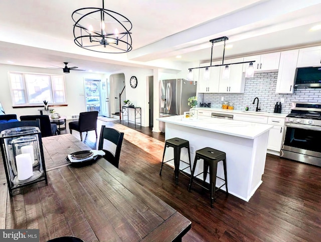 kitchen with appliances with stainless steel finishes, pendant lighting, white cabinetry, and sink