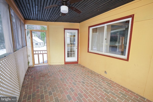 unfurnished sunroom with ceiling fan