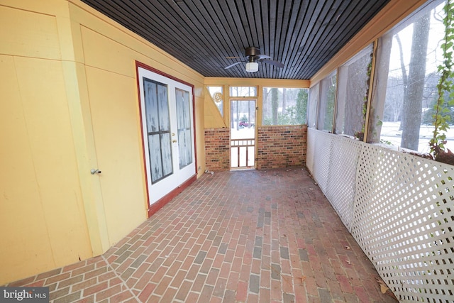 unfurnished sunroom with ceiling fan