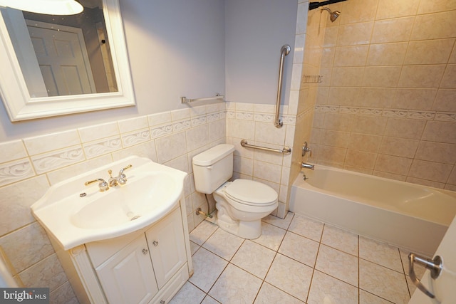 full bathroom featuring tile walls, toilet, tile patterned floors, vanity, and tiled shower / bath combo