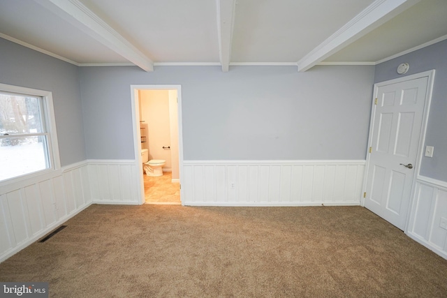 carpeted empty room featuring beam ceiling and crown molding